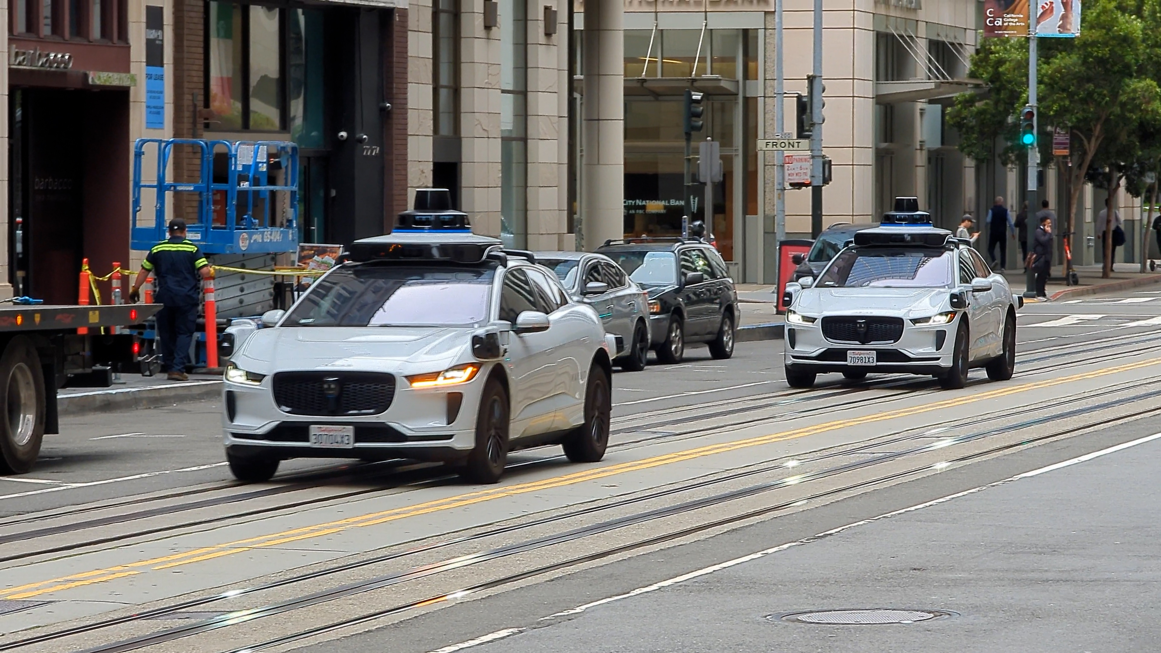 Waymo self-driving vehicles travel along California Street in San Francisco, Calif.
