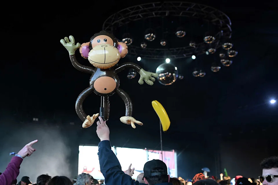A concert goer dances with an inflatable monkey inside the Ship Tent at the Portola Music Festival on Saturday Sept. 20, 2025. (Charles Russo/SFGATE)