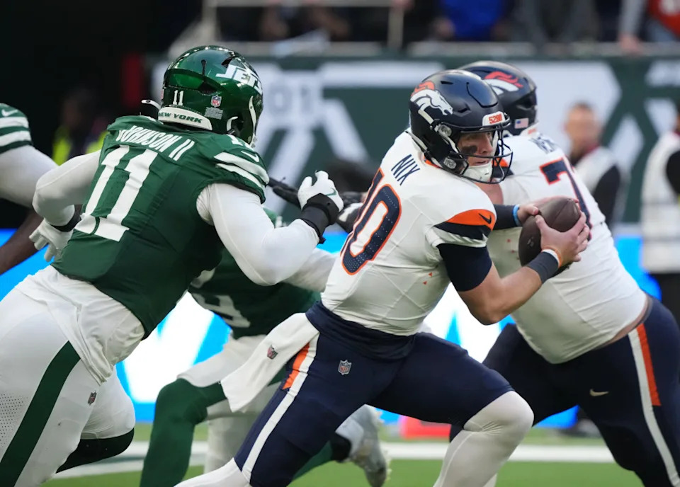 Oct 12, 2025; Tottenham, United Kingdom; Denver Broncos quarterback Bo Nix (10) is pressured by New York Jets linebacker Jermaine Johnson II (11) during an NFL International Series game at Tottenham Hotspur Stadium. Mandatory Credit: Kirby Lee-Imagn Images