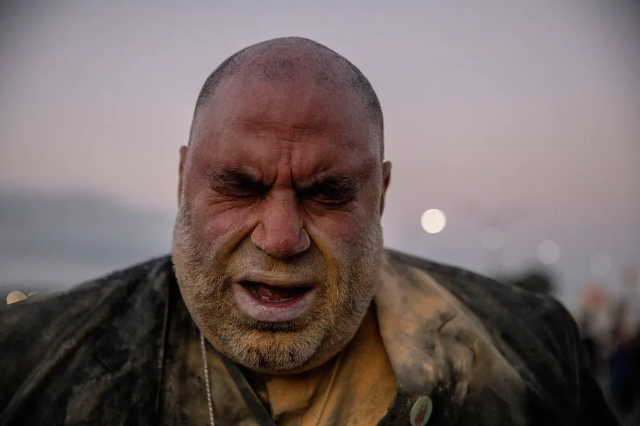 Jorge Bautista, a clergyman with the United Church of Christ, reacts after he was hit in the face by a pepper round from a U.S. Customs and Border Protection agent as protesters blocks the entrance to Coast Guard Island Alameda in Oakland on Oct. 23, 2025. (Photo by Stephen Lam/San Francisco Chronicle via Getty Images)