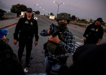 A U.S. Customs and Border Protection agent confronts protesters blocking the entrance to the Coast Guard Island Alameda on Oct. 23, 2025. (Photo by Stephen Lam/San Francisco Chronicle via Getty Images)