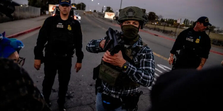 A U.S. Customs and Border Protection agent confronts protesters blocking the entrance to the Coast Guard Island Alameda on Oct. 23, 2025. (Photo by Stephen Lam/San Francisco Chronicle via Getty Images)