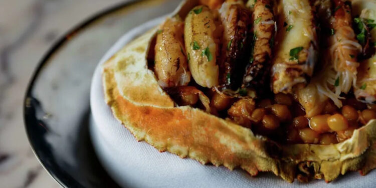 The whole Dungeness crab with fregola risotto, crab fat, uni butter and Meyer lemon-glazed crab legs at Bourbon Steak. (Yalonda M. James/S.F. Chronicle)
