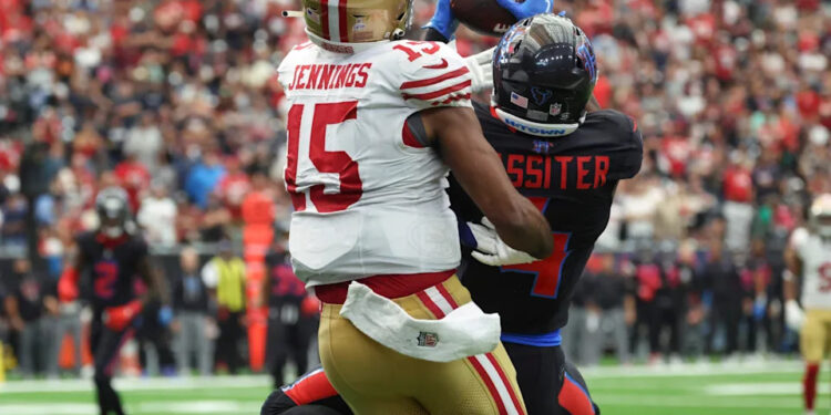 Oct 26, 2025; Houston, Texas, USA; Houston Texans cornerback Kamari Lassiter (4) intercepts a pass intended for San Francisco 49ers wide receiver Jauan Jennings (15) during the fourth quarter at NRG Stadium. Mandatory Credit: Troy Taormina-Imagn Images