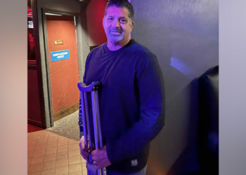 Mark Calcagni holding a pair of crutches