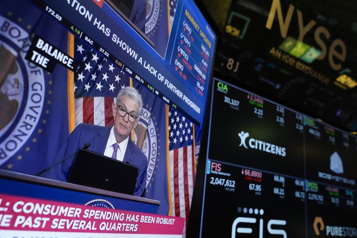 A TV monitor at the New York Stock Exchange showing a news conference.