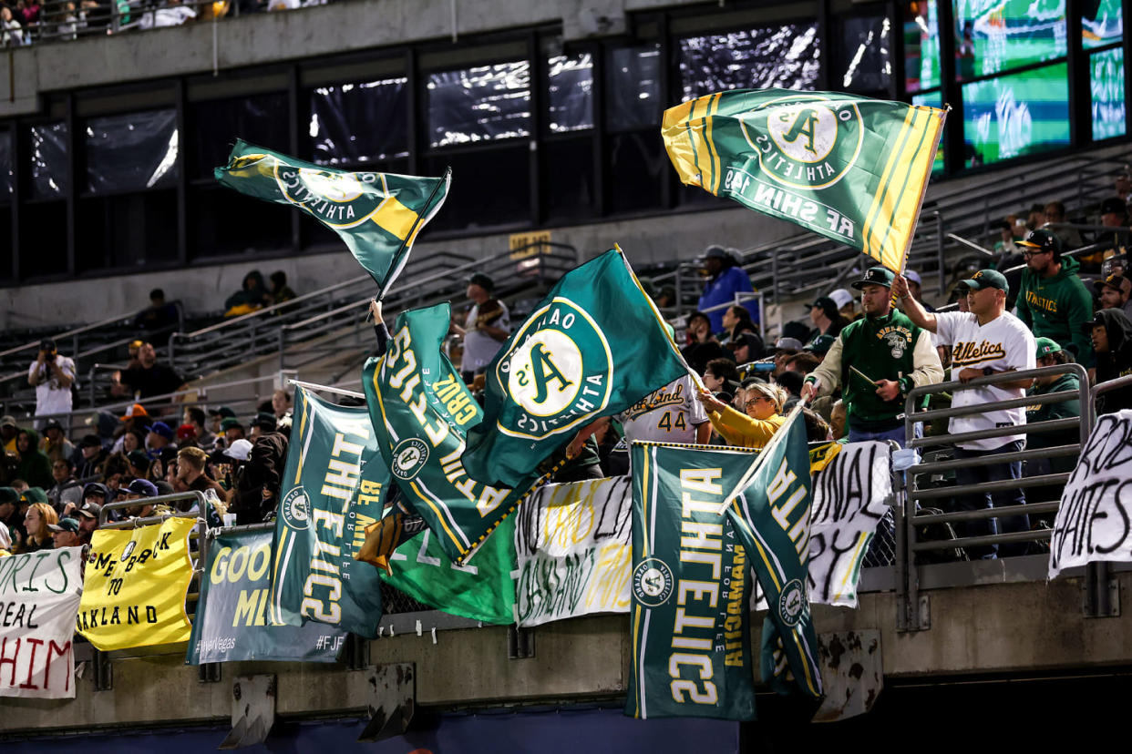 Fans wave Oakland Athletics fans in the stands of a stadium (Ezra Shaw / Getty Images)