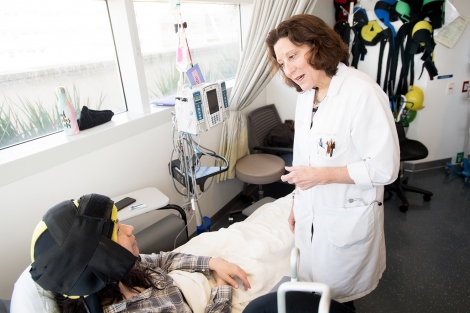 Melissa Diaz, wearing a scalp cooling device, talks to Hope Rugo 