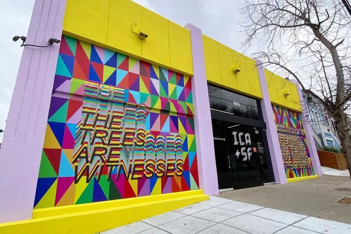 Exterior of ICASF building painted in yellow and purple with a geometric colorful mural reading 