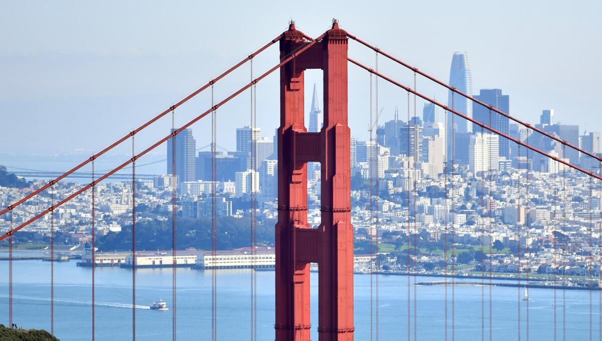 A view of the San Francisco skyline through the towers of the Golden Gate Bridge. 